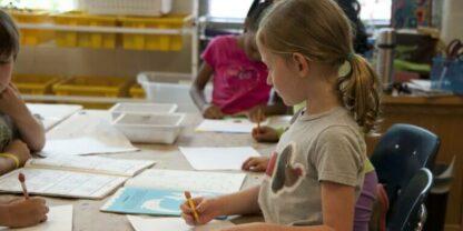 A young girl working on hands-on activities in a classroom.